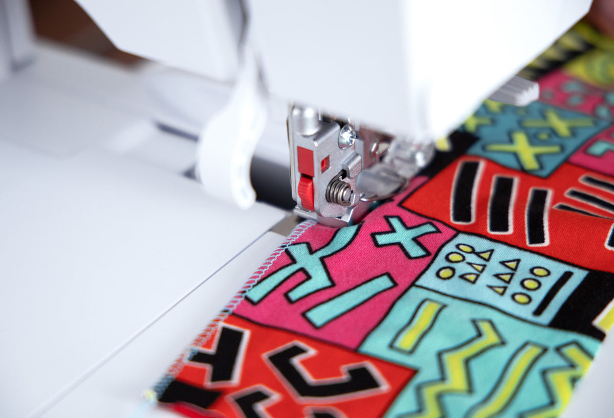 BERNINA L860 Serger close-up of needle and presser-foot area while overlocking fabric