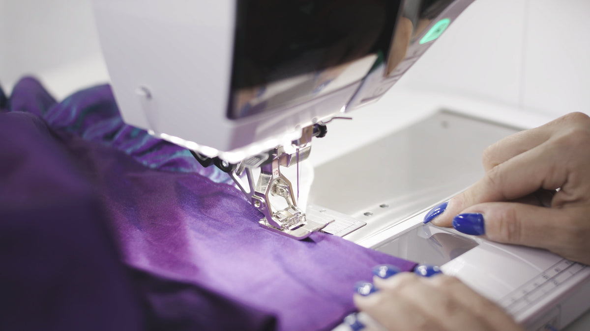 BERNINA 590 - needle and presser foot sewing purple fabric from an angled view